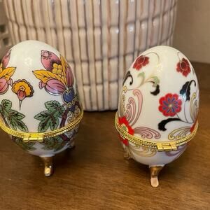 Pair of ceramic painted egg shaped trinket boxes